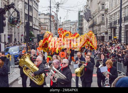 London, Großbritannien. 1. Januar 2023 Die Teilnehmer treten mit einem chinesischen Drachen auf der Londoner Neujahrsparade in Piccadilly auf. LNYDP ist eine jährliche Parade durch die Straßen des Londoner West End. Stockfoto