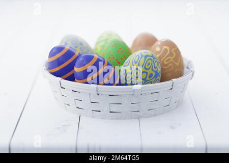 Farbenfrohe Ostereier in einem weißen Korb auf einem Holztisch. Ostern Stillleben. 3D Rendern.. Stockfoto