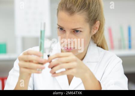 Wissenschaftlerin Hinzufügen flüssiger Rohr mit Pipette zu testen Stockfoto