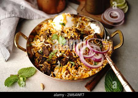 Hausgemachter Ziegenbraten-Biryani | Mutton dum Biryani serviert mit Joghurt-Rita, selektiv im Fokus Stockfoto