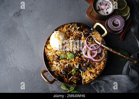 Hausgemachter Ziegenbraten-Biryani | Mutton dum Biryani serviert mit Joghurt-Rita, selektiv im Fokus Stockfoto