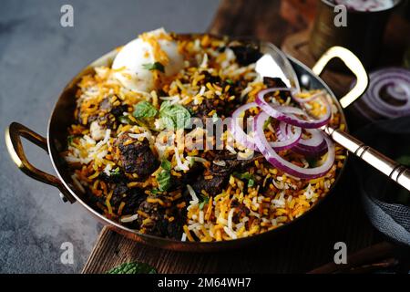 Hausgemachter Ziegenbraten-Biryani | Mutton dum Biryani serviert mit Joghurt-Rita, selektiv im Fokus Stockfoto