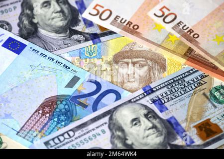 Die ukrainische Hrywna ist von Euro- und US-Dollar-Banknoten umgeben. Konzept der europäischen und amerikanischen Hilfe für die Ukraine, Wechselkurs Stockfoto