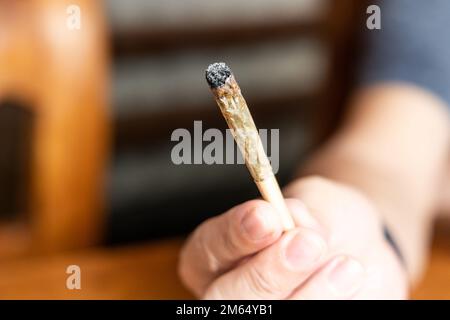 Finger halten gebrauchte Cannabiszigarette und bereit zum Rauchen Stockfoto