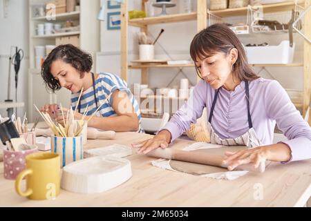 Zwei Frauen, die mit Ton in einer Töpferwerkstatt arbeiten. Handwerk, Kunst und Hobbys. Stockfoto