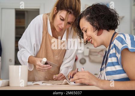 Zwei Frauen, die mit Ton in einer Töpferwerkstatt arbeiten. Handwerk, Kunst und Hobbys. Stockfoto