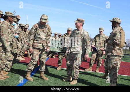 JROTC-Kadetten verschiedener High School erhalten Anweisungen, wie man einen Wurf ordnungsgemäß transportiert, während der vom Maryland Army National Guard gesponserten jährlichen Raiders Challenge 1. an der Fairmont Heights High School in Landover, Maryland, am 2. April 2022. Die Kadetten nahmen auch an anderen Veranstaltungen Teil, bei denen ihre Stärke und ihre Fähigkeit, als Team zu arbeiten, auf die Probe gestellt wurden. Stockfoto