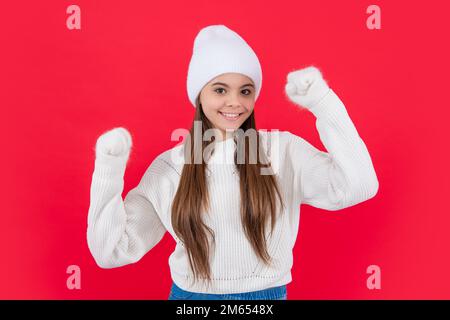 Lächelndes Teenager-Mädchen in warmer Winter Strickmode Pullover und Fäustlinge im Studio. Ein junges Wintermädchen Stockfoto