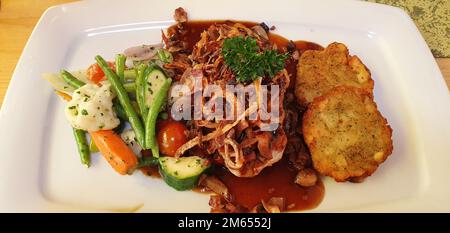 Schweinefilet mit Biersauce, Pilzen und gebratenen Zwiebeln, mit einer Seite Rosti-Kartoffeln und Gemüse Stockfoto