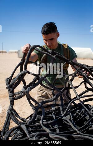 USA Marine Corps Lance CPL. Lazaro Cisneros Jr., ein Spezialist für Landungsunterstützung beim Combat Logistics Battalion 45, Landing Support Company, 4. Marine Logistics Group, passt Frachtnetze auf Reifen während der Integrated Training Exercise 3-22 am Marine Corps Air Ground Combat Center Twentynine Palms, Kalifornien, 2. April 2022 an. ITX ist ein Live-Fire-Ereignis, das die Einsatzbereitschaft der Einheit erhöht. Er lehrt die taktische Anwendung kombinierter Waffenmanöver, Offensive und Defensive während des Kampfes. Stockfoto