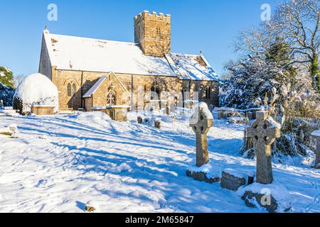 Frühwinterschnee in der St. Michael & All Angels Kirche des 12. Jahrhunderts im Dorf Cotswold in Brimpsfield, Gloucestershire, England Stockfoto