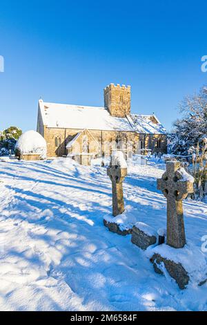 Frühwinterschnee in der St. Michael & All Angels Kirche des 12. Jahrhunderts im Dorf Cotswold in Brimpsfield, Gloucestershire, England Stockfoto