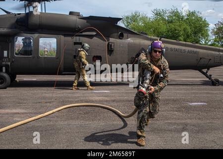 EIN US-AMERIKANISCHER Marinesoldat wurde dem Marinesoldat 172 (MWSS-172) zugeteilt, und ein Soldat mit der 25. Kampfluftfahrtbrigade, 25. Infanteriedivision, hat einen Army UH-60 Hawk Helikopter an einem vorderen Scharfstellen- und Tankpunkt aufgetankt, während Balikatan 22 in Subic Bay, Philippinen, 3. April 2022. Balikatan ist eine jährliche Übung zwischen den Streitkräften der Philippinen und dem US-Militär, die darauf abzielt, die bilaterale Interoperabilität, Fähigkeiten, Vertrauen und Zusammenarbeit zu stärken, die über Jahrzehnte hinweg aus gemeinsamen Erfahrungen aufgebaut wurden. Balikatan, Tagalog für „Schulter-zu-Schulter“, ist ein langjähriges bilaterales Abkommen Stockfoto