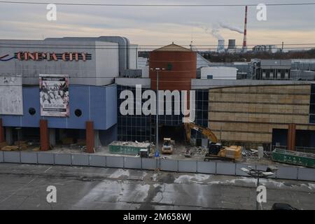 Verlassenes Einkaufszentrum, das gerade abgerissen wird (mit einem Rauchkraftwerk im Hintergrund) Stockfoto