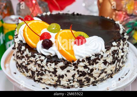 Ein köstlicher und wunderschöner Kuchen dekoriert mit Kirschen, Kiwi und Orange. Ukraine, Winnytsia, 10. August 2021 Stockfoto