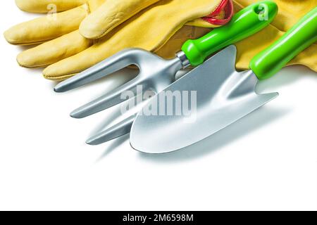 Gartengabel und Handspaten für Agro-Werkzeuge mit gelben Arbeitshandschuhen isoliert weiß Stockfoto