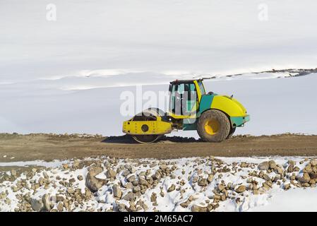 Straßenwalze Industriemaschinen für hohe Beanspruchung auf der Baustelle, im Winter mit Schnee bedeckt auf dem Berg Zlatibor, Serbien Stockfoto