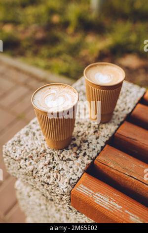 Zwei Pappbecher Cappuccino mit Latte Art. Wunderschöner Schaum, Kaffee zum Mitnehmen Stockfoto