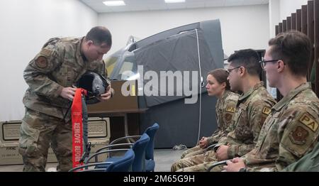 Staff Sergeant Jason Konrad, 509. Operations Support Squadron, Aircrew Flight Equipment, unterrichtet Flugzeuge vom Public Affairs Office über die Feinheiten des Helms, den sie auf ihren Flügen tragen werden, als Teil der Übung Agile Tiger auf der Whiteman Air Force Base, Missouri, 4. April 2022. Spezialisten für öffentliche Angelegenheiten, von rechts, Airman 1. Klasse Bryson Britt, Airman 1. Klasse Joseph Garcia und Airman 1. Klasse Victoria Hommel dokumentierte Übung Agile Tiger vom Rücksitz eines T-38 Talon. Stockfoto