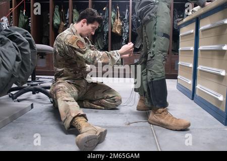 Staff Sgt. Anthony Murea, 509. Einsatzstaffel, Flugausrüstung, schnürt Schnürsenkel an einem Anti-Gravitation-Anzug, oder G-Suit, für 509. Public Affairs Specialist Airman 1. Class Bryson Britt vor seinem Flug auf dem Whiteman Air Force Base, Missouri, am 4. April 2022. A1c Britt flog auf dem Rücksitz eines T-38 Talons, um Übung Agile Tiger zu dokumentieren. Stockfoto