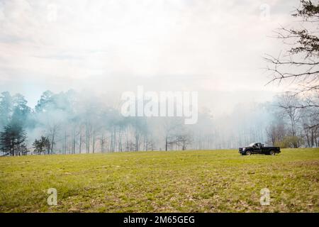 Rauchfahnen treten aus dem Wald auf, während Quantico Fire & Emergency Services und Natural Resources Environmental Affairs (NREA) kontrollierte Verbrennungen an der Marine Corps Basis Quantico, Virginia, durchführen, 4. April 2022. Laut NREA besteht der Zweck der Verbrennung darin, die Menge an Brennstoff zu reduzieren, das Potenzial von Waldbränden zu minimieren und die Lebensräume der Wildtiere zu fördern. Bei Kraftstoffstreu handelt es sich um tote und ausgetretene Holzschutt, die als Brennstoff für Waldbrände oder andere potenzielle Gefahren verwendet werden könnten. Darüber hinaus kann überschüssiges Laub den natürlichen Nährstofffluss im Boden und im Ökosystem insgesamt stören. Die Verbrennungen sind carrie Stockfoto