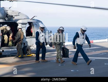 220404-N-TT639-1168 PAZIFIK (4. April 2022) – Master Chief Petty Officer of the Navy (MCPON) Russell Smith, Zentrum, kommt an Bord des Amphibienschiffs USS Tripoli (LHA 7), April 4. Tripoli führt gerade Routineeinsätze in der US-3.-Flotte durch. Stockfoto