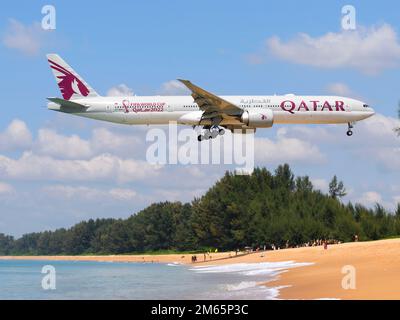 Qatar Airways Boeing 777 Flugzeug über Mai Khao Beach. Flugzeuge von Qatar Airways 777-300ER mit Qatar 2022 Aufkleber. Stockfoto