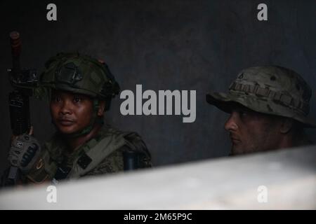 EIN US-AMERIKANISCHER Army Pacific Soldier ist dem 2. Bataillon, 27. Infanterie-Regiment, 3. Brigaden-Kampfteam 25. Infanterie-Division zugeteilt, mit einem philippinischen Soldaten, der Kompanie B, 92. Infanterie-Bataillon, 1. Brigaden-Kampfteam verteidigt ihre Position bei einem simulierten Angriff auf eine Militäroperation im städtischen Gelände gegen US-Streitkräfte und philippinische Streitkräfte im Rahmen der Übung Balikatan in Fort Magsaysay, Nueva Ecija, Philippinen, am 5. April 2022. Balikatan ist eine jährliche Übung zwischen den Streitkräften der Philippinen und dem US-Militär zur Stärkung der bilateralen Interop Stockfoto