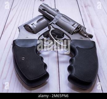 Zwei Nasen-Revolver aus Edelstahl, eine 357 Magnum und eine 44 Spezial auf weißem Holzhintergrund Stockfoto