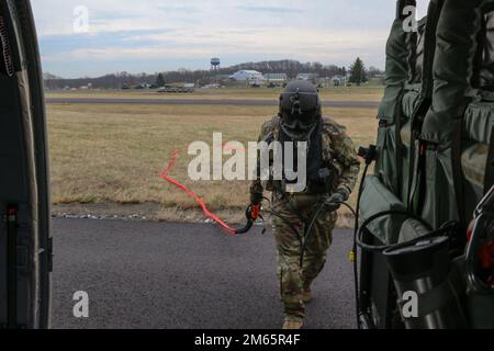 Sgt. 1. Klasse Kyle Moyer, der Chef der Flugbesatzung und Ausbilder am Flugschulgelände der Eastern Army National Guard Aviation Training Site (EAATS), bereitet sich auf die Durchführung eines Wassereimer-Trainings vor, indem er das Eimerseil in den Hubschrauber UH-60m Black Hawk am 5. April in Fort Indiantown Gap bringt. Diese gemeinsame Schulung der EAATS und der Feuerwehrleute für Naturschutz verbessert ihre Fähigkeit, Wassereimer als Ressource für Waldbrände oder vorgeschriebene Verbrennungen zu verwenden. Stockfoto