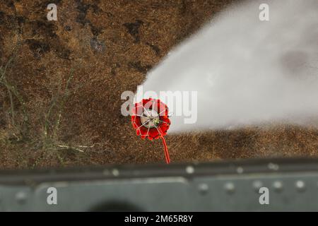 Sgt. 1. Class Kyle Moyer, ein UH-60m Black Hawk Hubschrauber Crew Chief und ein Lehrer am Eastern Army National Guard Aviation Training Site (EAATS), drückt einen Knopf, um Wasser aus dem Boden des Eimers auf ein schwelendes kontrolliertes Feuer während des Trainings am 5. April in Fort Indiantown Gap abzulassen. Diese gemeinsame Schulung der EAATS und der Feuerwehrleute für Naturschutz verbessert ihre Fähigkeit, Wassereimer als Ressource für Waldbrände oder vorgeschriebene Verbrennungen zu verwenden. Stockfoto