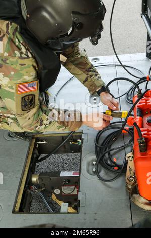 Sgt. 1. Klasse Kyle Moyer, der Chef der Flugbesatzung und Ausbilder an der Flugübungsstätte der Eastern Army National Guard Aviation Training Site (EAATS), löst den Wassereimer vom UH-60m Black Hawk Helikopter nach der Wassereimer-Schulung am 5. April in Fort Indiantown Gap. Diese gemeinsame Schulung der EAATS und der Feuerwehrleute für Naturschutz verbessert ihre Fähigkeit, Wassereimer als Ressource für Waldbrände oder vorgeschriebene Verbrennungen zu verwenden. Stockfoto