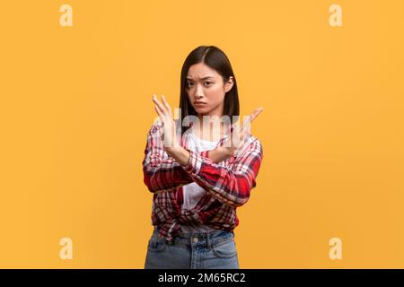 Portrait einer durchsetzungsfähigen asiatischen Dame, die HALT oder GENUG Gesten zeigt, etwas ablehnt, ihre Leugnung ausdrückt, NEIN sagt Stockfoto