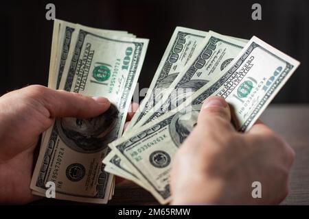 Ein Mann hat Hundert-Dollar-Scheine in der Hand Stockfoto
