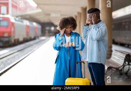 Zu Spät Zum Zug. Gestresstes Schwarzes Paar Steht Auf Bahnsteig Am Bahnhof Stockfoto