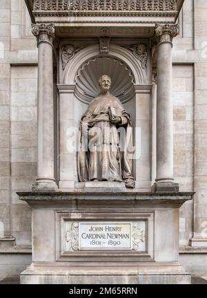 Ein vertikales Bild einer Statue von John Henry Cardinal Newman vor dem Brompton Oratory in London, Großbritannien Stockfoto