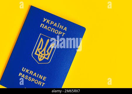 Ukrainischer Pass auf gelbem Hintergrund. Der Pass des ukrainischen Staatsbürgers im Makro. Reisepass Allgemeiner Plan und Nahaufnahme. Stockfoto