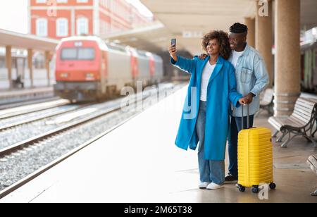 Glückliches Junges Schwarzes Paar, Das Selfie Auf Dem Smartphone Am Bahnhof Mitnimmt Stockfoto