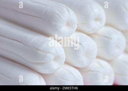 Medizinische weibliche Tampon-Nahaufnahme. Hygienischer weißer Tampon für Frauen. Wattestäbchen. Menstruation, Schutzmittel. Tampons auf rotem Hintergrund. Stockfoto