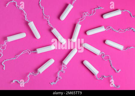 Medizinische weibliche Tampons auf rosa Hintergrund. Hygienischer weißer Tampon für Frauen. Wattestäbchen. Menstruation, Schutzmittel. Tampons auf einem roten Backgrou Stockfoto