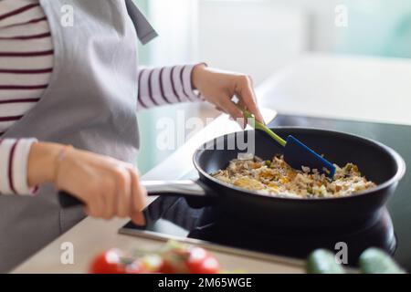 Gekürzt von einer Frau, die ein gesundes Abendessen macht, das Essen zu Hause zubereitet Stockfoto