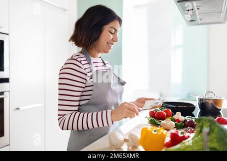 Junge Hausfrau, die Frühstück für die Familie macht Stockfoto