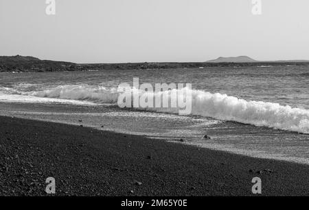 Der Kontrast zwischen der smaragdfarbenen Lagune und den schwarzen Körnern des Strandes ist so erstaunlich. Der schwarze Strand von Lanzarote, Kanarische Inseln Stockfoto