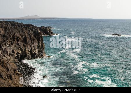 Der Kontrast zwischen der smaragdfarbenen Lagune und den schwarzen Körnern des Strandes ist so erstaunlich. Der schwarze Strand von Lanzarote, Kanarische Inseln Stockfoto