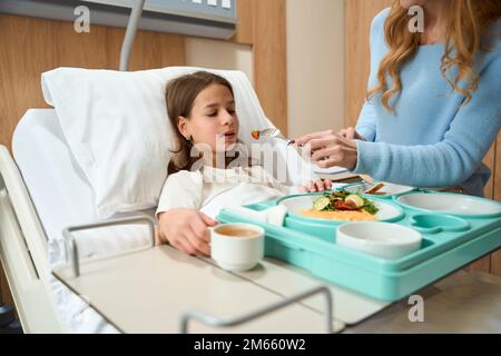 Schwaches Mädchen liegt auf einem Krankenhausbett Stockfoto