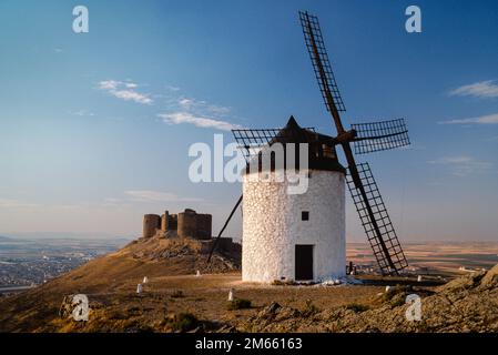 Spanische Windmühle, Blick auf eine historische Windmühle und Burg auf einem Hügel in Consuegra mit Blick auf die Ebene von La Mancha, Castilla-La Mancha, Spanien Stockfoto