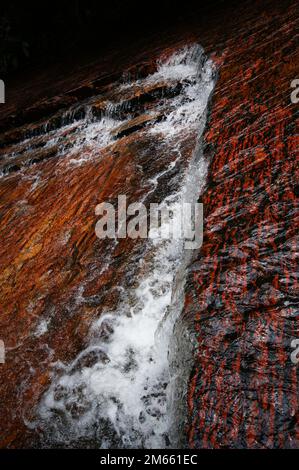 Wasserfall mit rotem Jasper-Flussbett in Quebrada de Jaspe, Jasper Creek, Gran Sabana, Venezuela Stockfoto