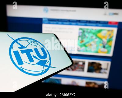 Mobiltelefon mit Logo der Internationalen Fernmeldeunion (ITU) auf dem Bildschirm vor der Website. Fokus auf die Mitte links des Telefondisplays. Stockfoto