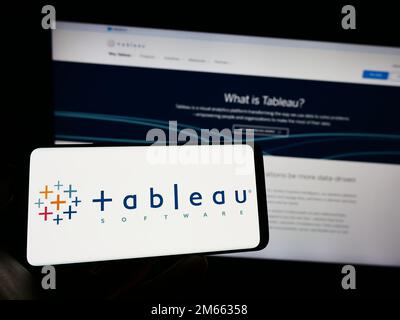 Person, die ein Mobiltelefon mit dem Logo des US-Unternehmens Tableau Software Inc. Auf dem Bildschirm vor der geschäftlichen Webseite hält. Konzentrieren Sie sich auf das Display des Telefons. Stockfoto