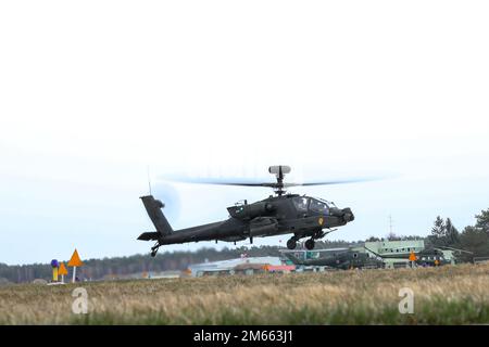 Ein AH-64E Apache-Angriffshubschrauber, der der 1. Luftkavallerie-Brigade, 1. Kavallerie-Division zugeteilt ist, startet von einem vorderen Bewaffnungs- und Tankpunkt in Milroslawiec, Polen, 4. April 2022. Stockfoto